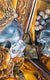 detail of a painting featuring gilded rose, leaves, and ornate mirror reflecting a silver skull adorned with a jeweled golden crown and pearls on a bed of golden hair. 