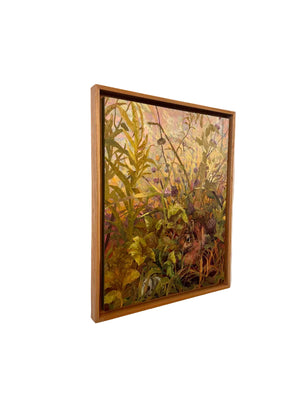 Framed painting of a natural scene with plants and a rabbit on a beige wall.