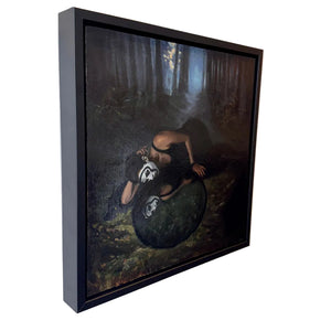 Framed artwork of a person in a dark forest with another figure on a rock.