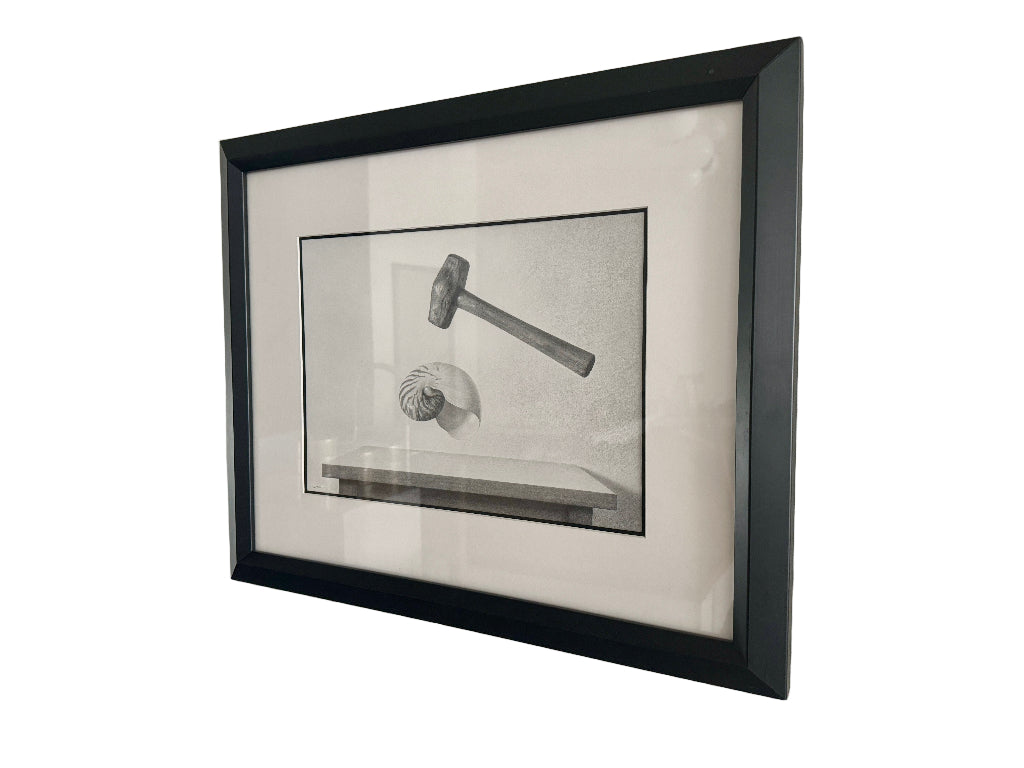 Framed black and white drawing of a gavel and shell on a light gray wall.