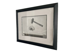 Framed black and white drawing of a gavel and shell on a light gray wall.