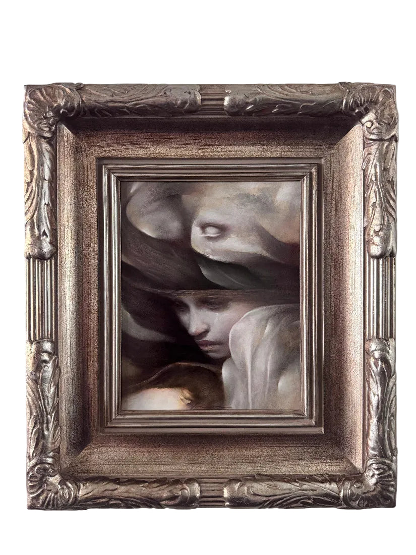 An ornate square framed painting featuring a classical-style portrait of a woman's face with draped shadows and pale flesh tones, set in a detailed metallic silver frame against a light gray wall.