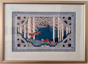 Framed artwork of foxes in a forest scene on a white wall
