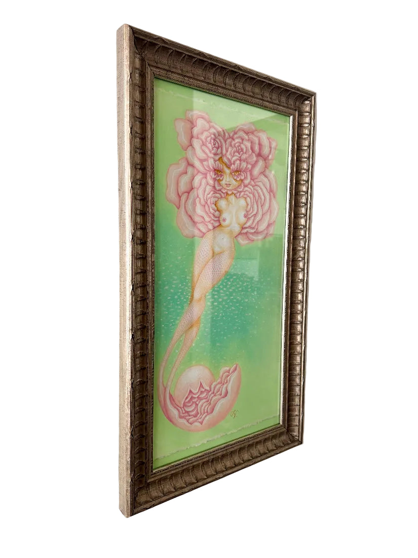 Framed artwork of a mermaid with a large pink flower on a green background, hanging on a wall.
