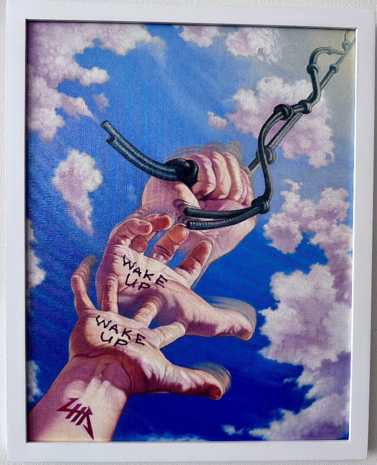 A framed painting featuring two reaching hands trying to grasp a chain, with the words 'WAKE UP' written on the palms, set against a blue sky with clouds. The print is mounted on a light wall with price and artist labels visible.