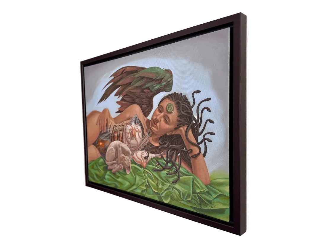 Framed artwork of a woman with long hair and tattoos on a wall.