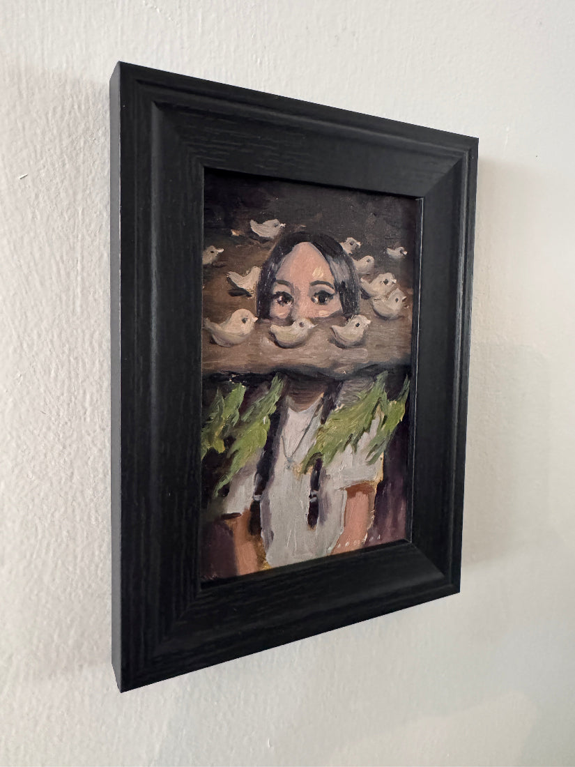 Framed artwork of a face with a black frame on a light background