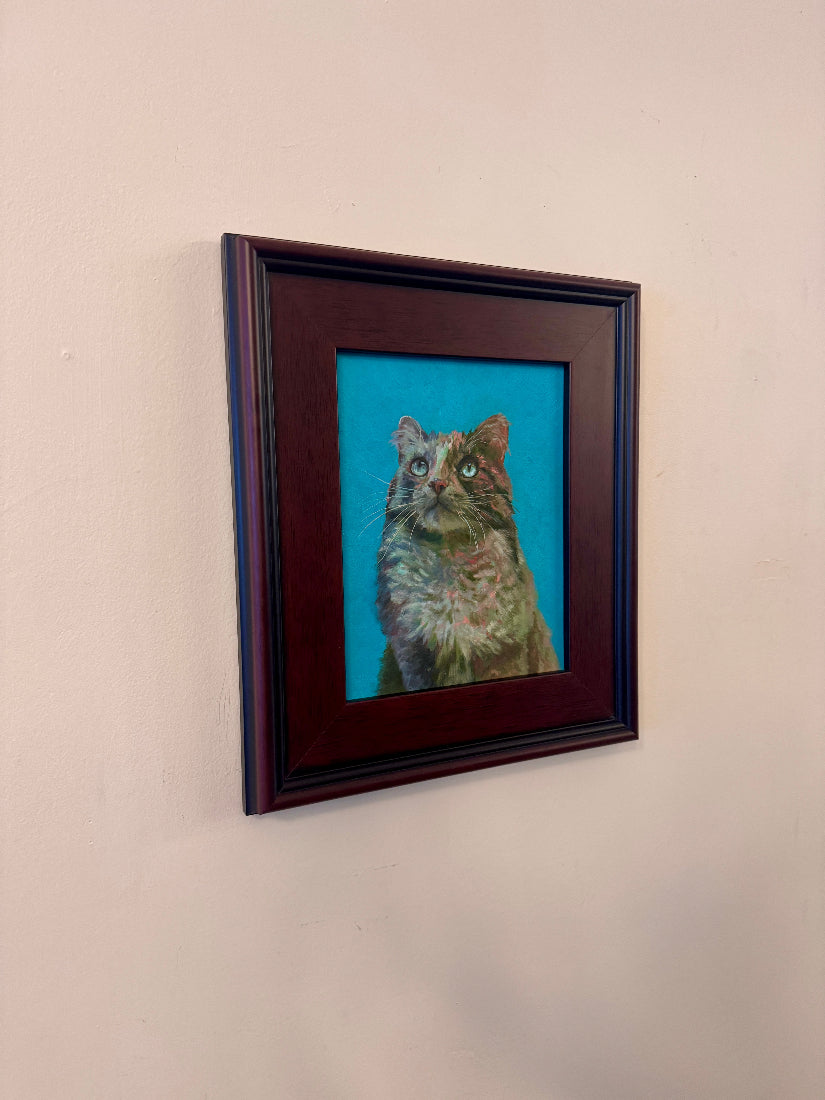 Framed painting of a cat on a beige wall