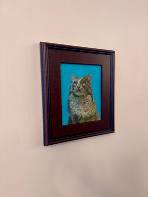Framed painting of a cat on a beige wall
