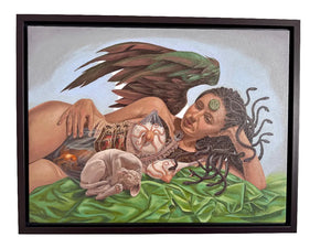 Framed artwork of a woman with wings and a cat on a green surface.