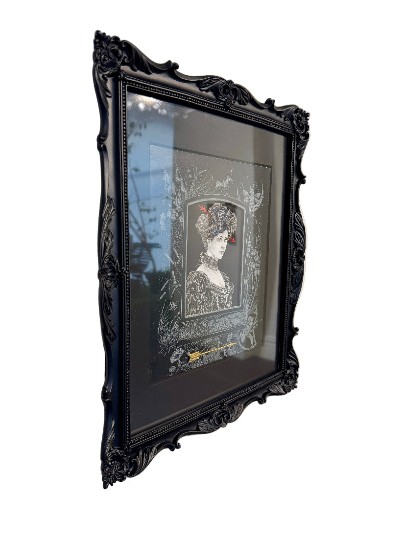 Black ornate frames with artwork on a white wall