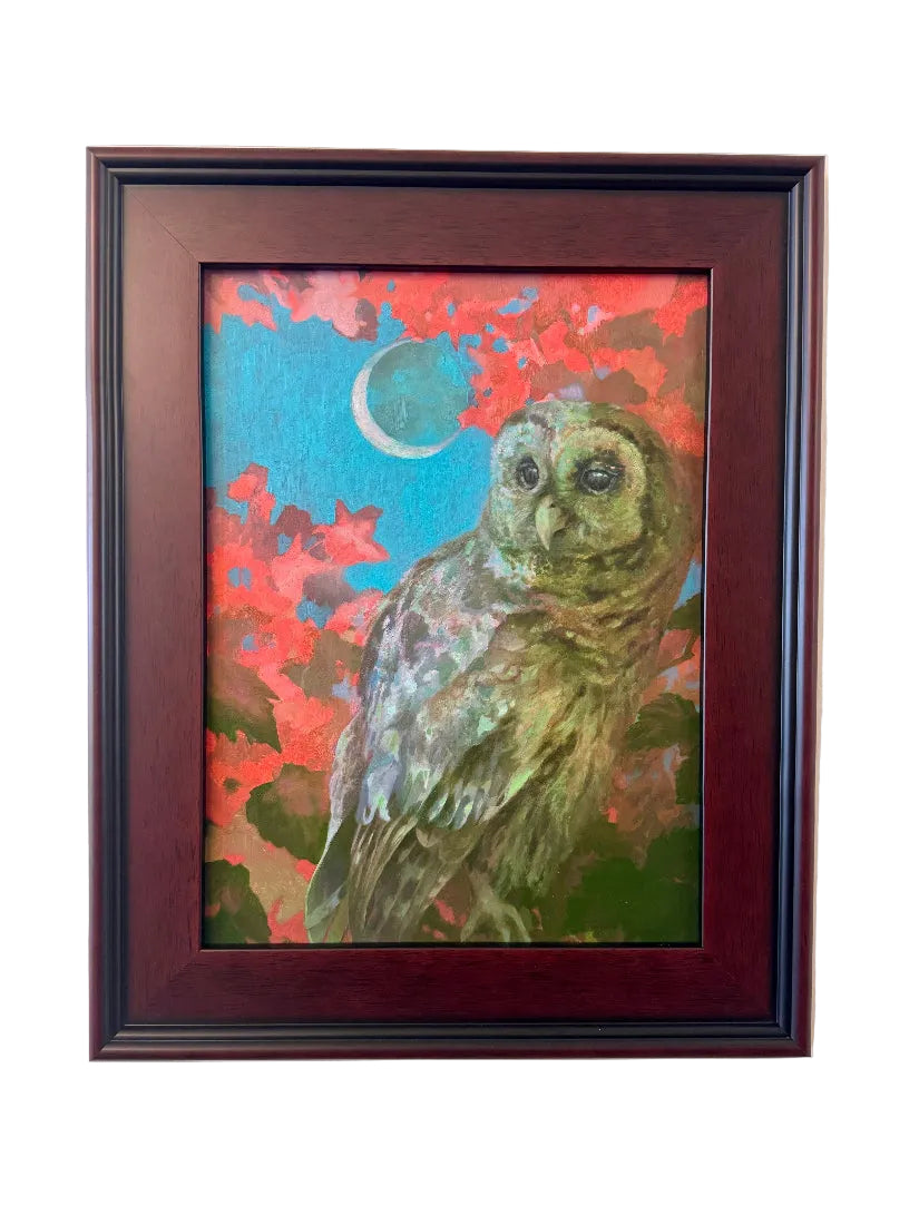 Framed artwork of an owl with a colorful background on a white wall