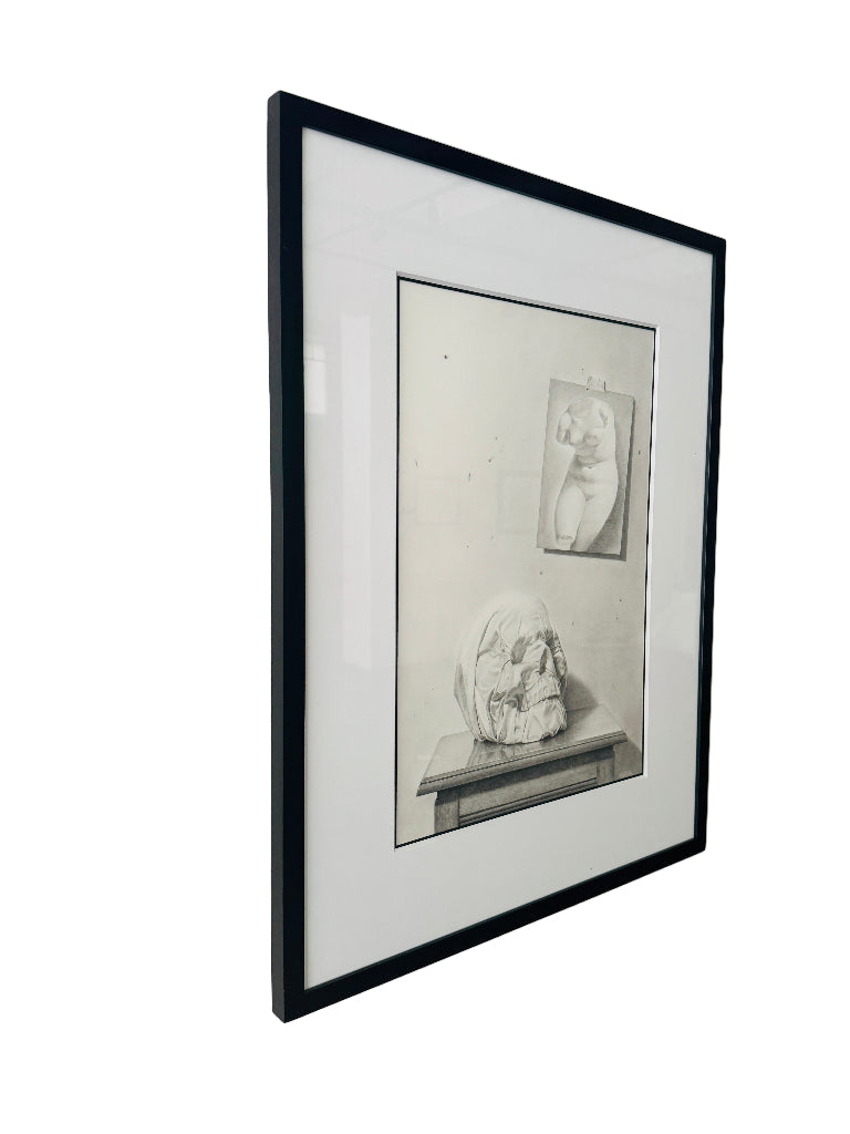 Framed black and white drawing of a sculpture on a white wall