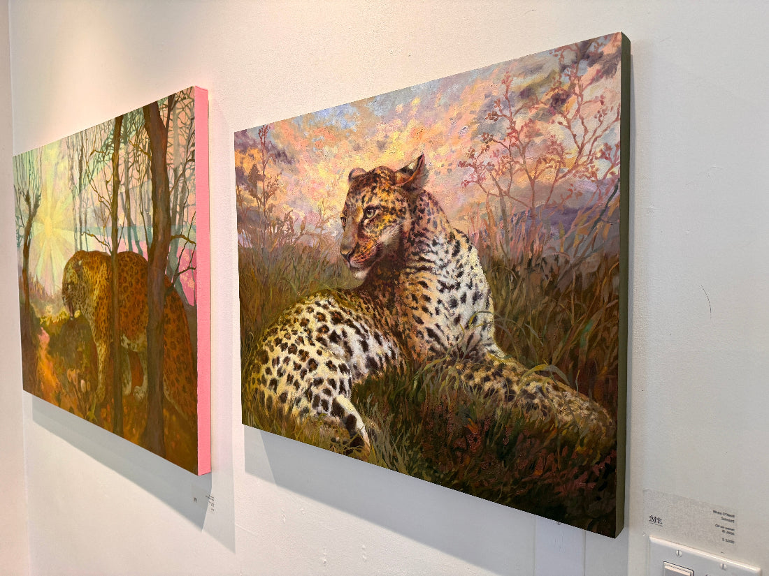 Two paintings of leopards in a natural setting on a wall.