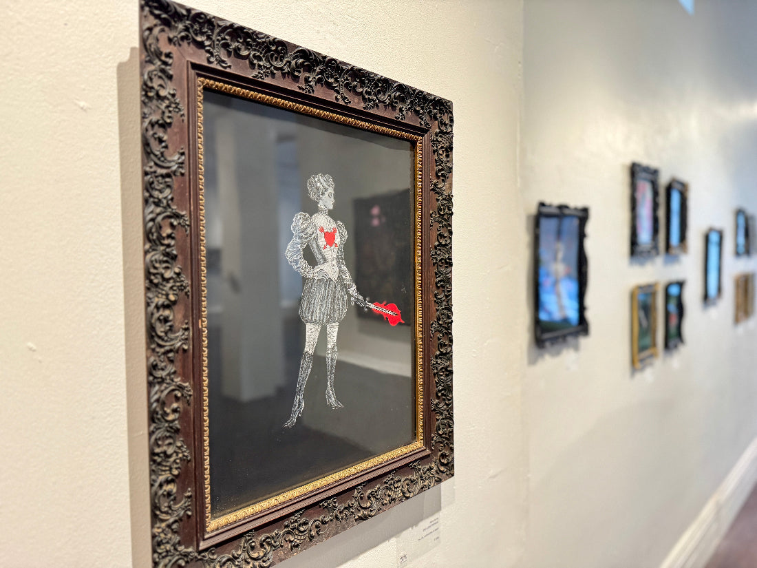 Decorative wall art with a detailed frame featuring a figure holding a heart.