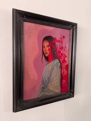 A framed portrait painting of a woman with dark hair, set against a pink and red background, housed in a thick black ornate frame and hanging on a white wall.