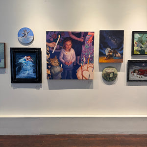 Art gallery wall with various paintings and artworks.