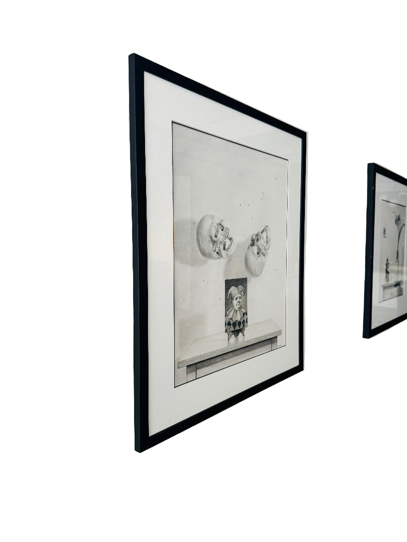 Two framed black and white drawings on a white wall.