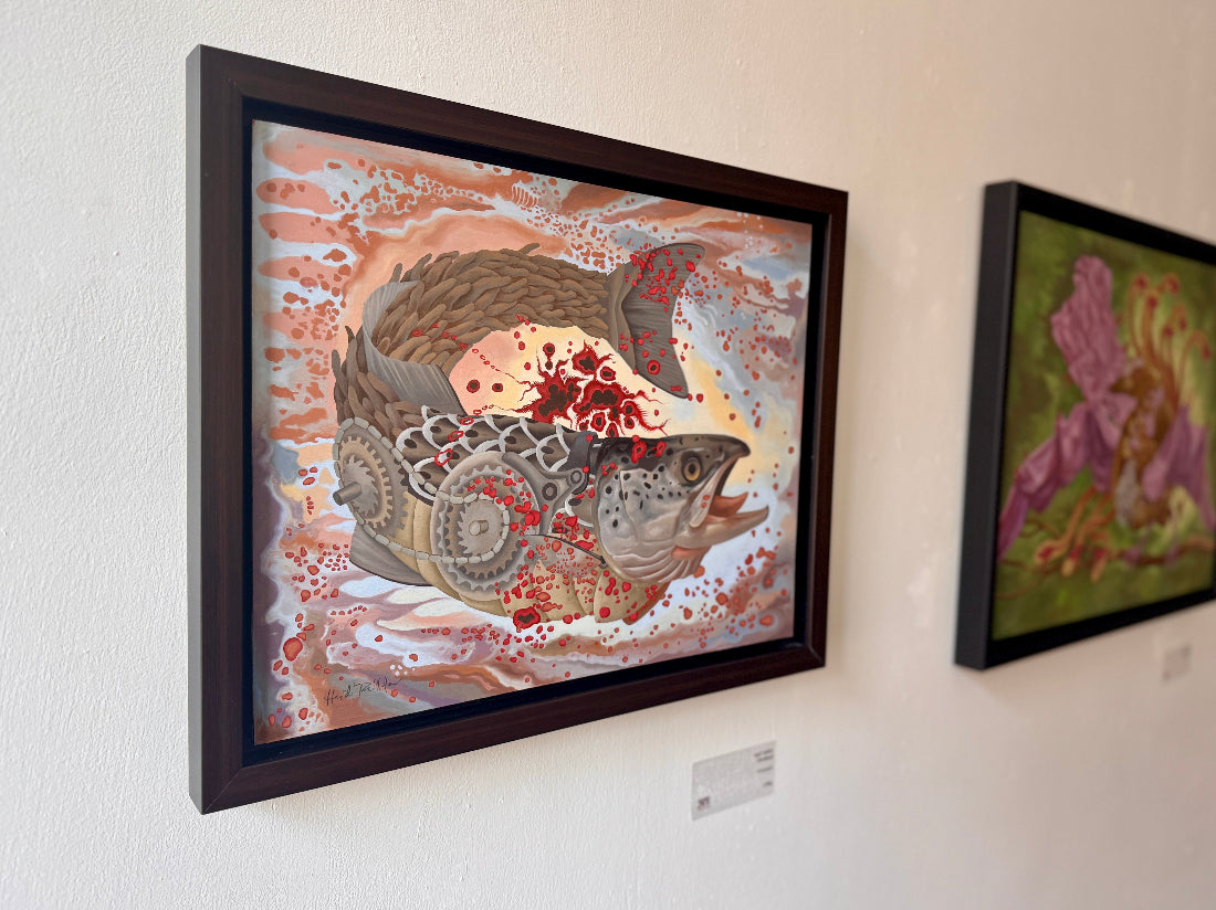 Framed artwork of a fish with intricate patterns on a white wall.