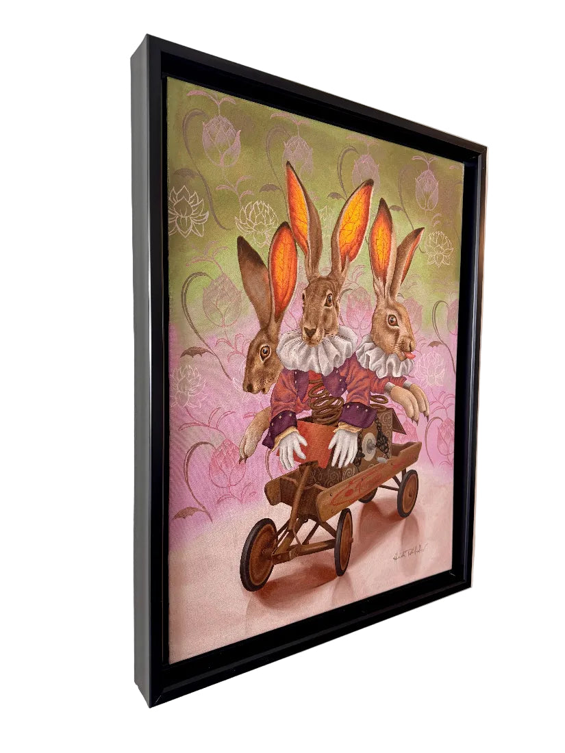 Framed artwork of two rabbits in a wheelbarrow on a decorative wall.