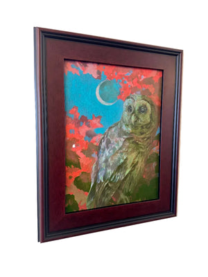 Framed artwork of an owl with a colorful background on a beige wall