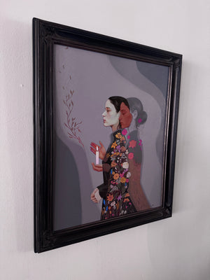 A framed painting featuring a stylized portrait of two women in profile, one in a floral patterned dress, hanging on a plain white wall.