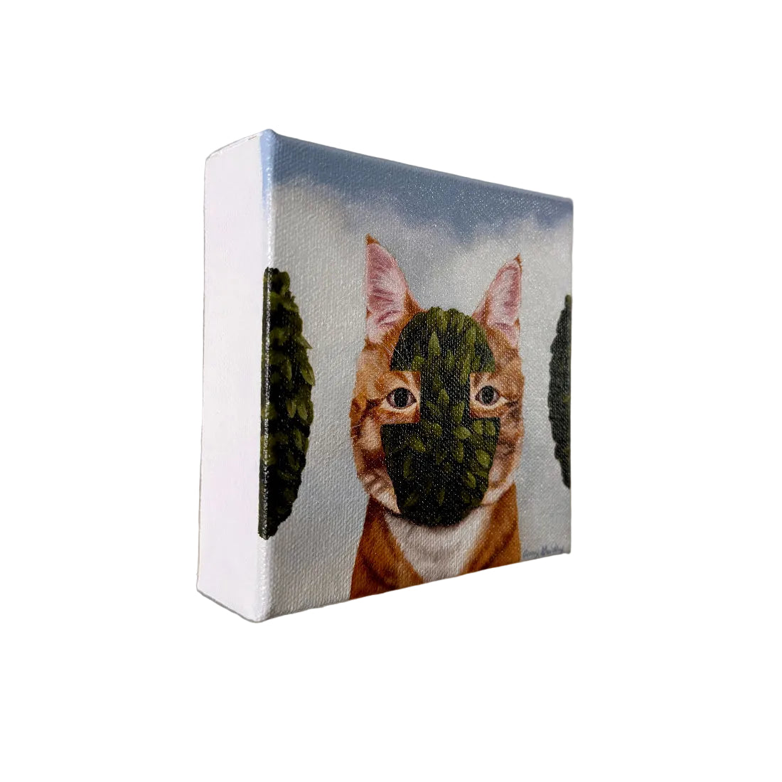 Canvas print of a cat with a leafy green mask on a plain wall