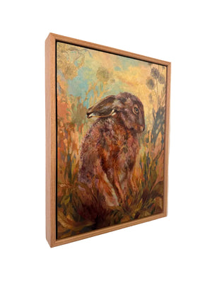 Framed painting of a hare in a natural setting on a wall.