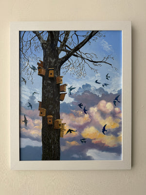 Framed artwork of a tree with birdhouses and flying birds against a colorful sky.