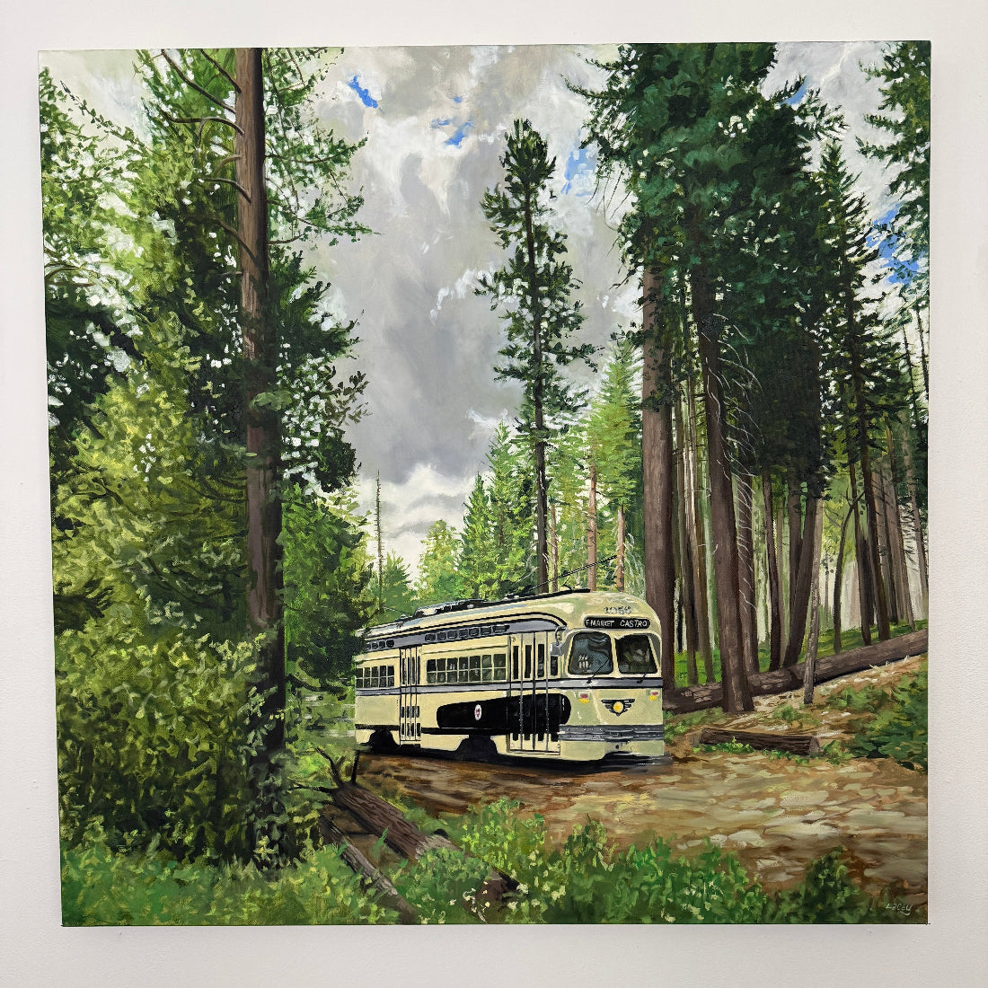 Vintage trolley in a forest setting with tall trees and a clear sky.