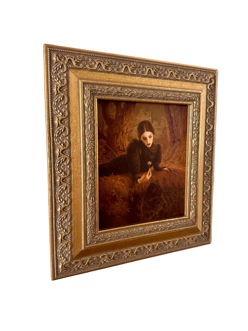 Framed portrait of a woman with a cat on a textured wall