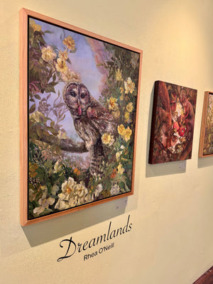 Framed artwork of an owl among flowers on a wall with 'Dreamlands Rhea O'Neill' text.