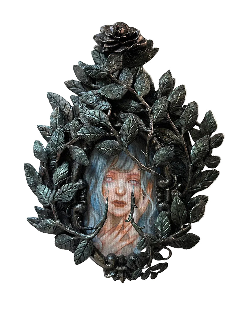 Decorative wall piece with a woman's face framed by leaves and roses on a white background