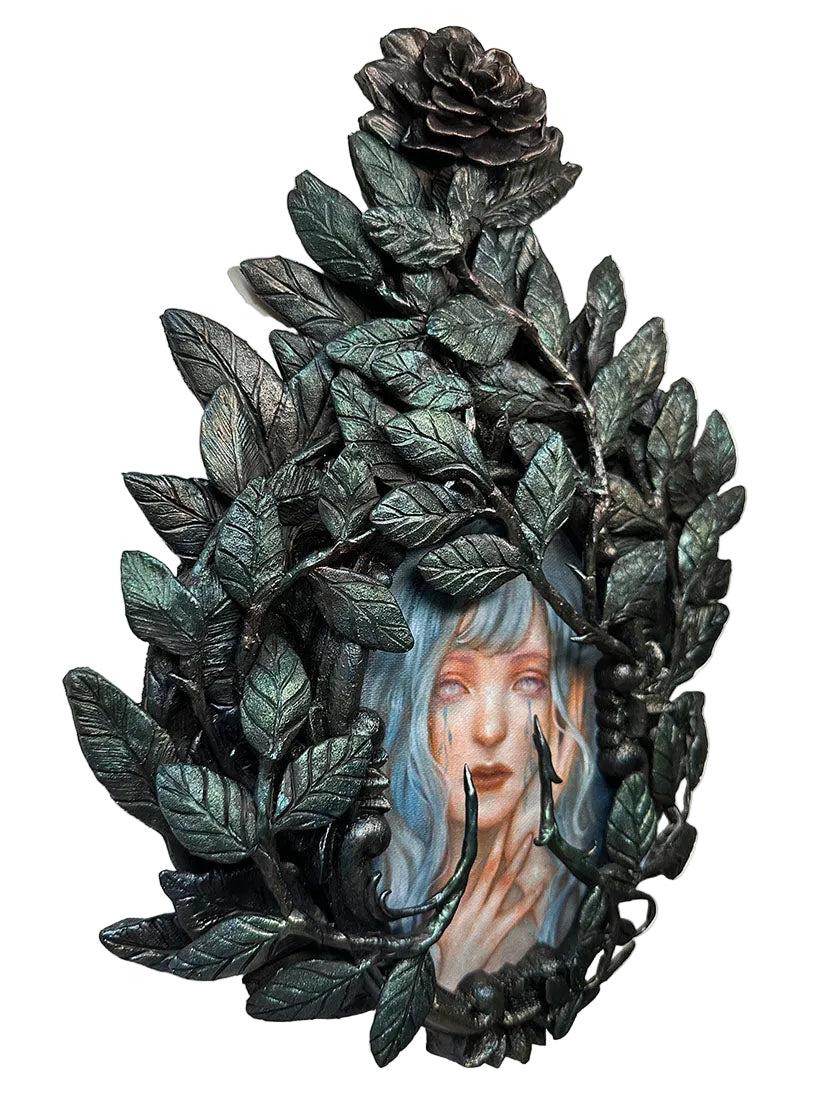 Decorative wall piece with a woman's face framed by leaves and roses on a white background