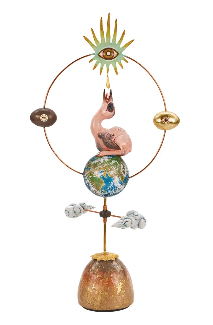 A whimsical hand-painted ceramic sculpture on a white background. The design features a pink flamingo perched on a globe, supported by a gold-toned pole with white clouds, a gold sun with an eye, and a circular wire frame with brown and gold orbs.