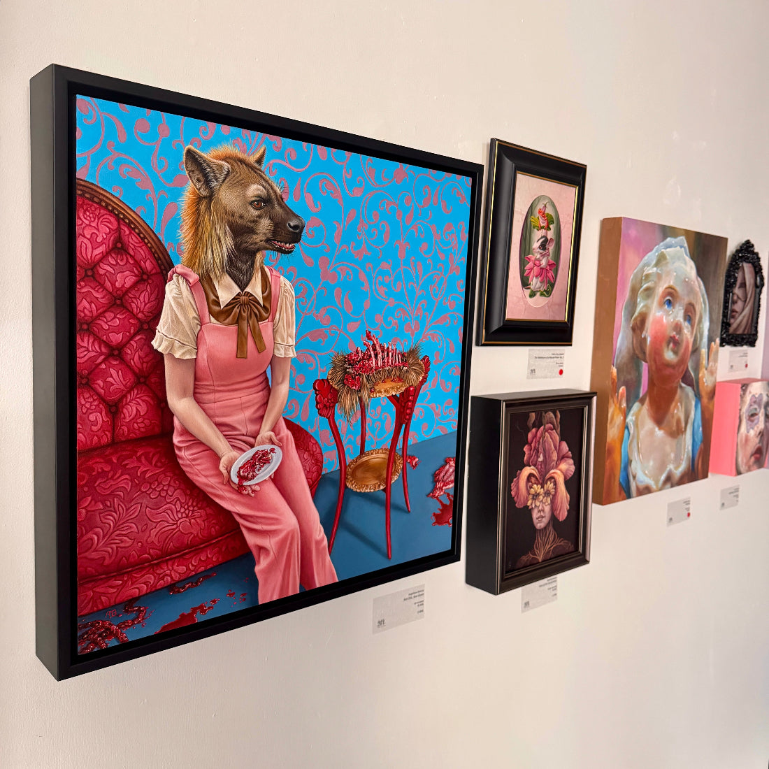 Art gallery wall with framed artworks featuring surreal and fantastical designs.