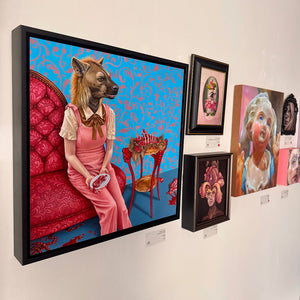 Art gallery wall with framed artworks featuring surreal and fantastical designs.