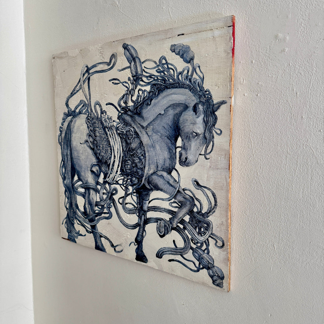 Decorative wall art of a horse with intricate details on a plain wall.
