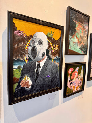 Framed artwork of a person wearing a gas mask on a wall with other artworks.