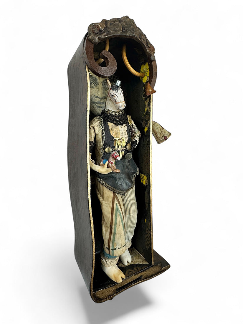 Small figure inside a wooden box with intricate details on a white background