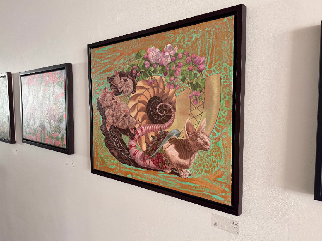 Framed artwork of a fantasy creature with floral elements on a white wall.