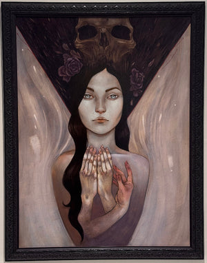 A framed surreal painting of a pale woman with clasped hands, a dark skull-like headpiece with roses, and flowing light drapery, displayed on a light wall.