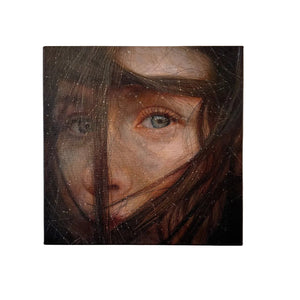A square canvas wall art painting featuring a close-up portrait of a woman's face obscured by dark hair, hung on a light beige wall.