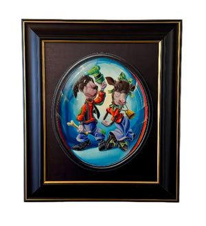 A framed oval wall art piece hanging on a plain off-white wall. The artwork shows two cartoon children in colorful outfits against a blue circular background, set within a black frame with a gold inner border.