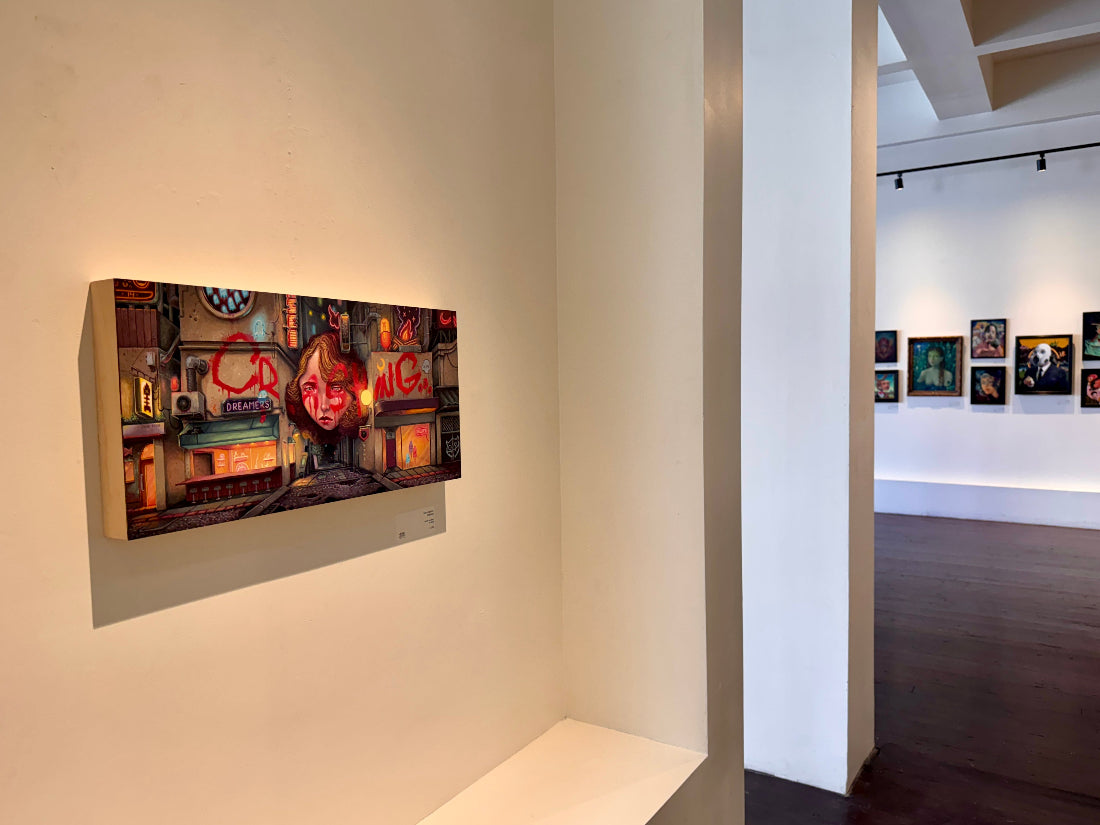 Art gallery with a large wall-mounted artwork and other framed pictures on the wall.