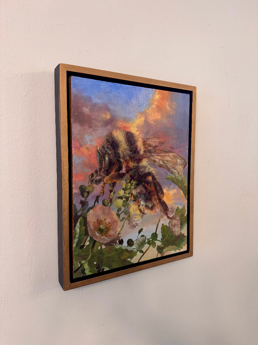 Framed artwork of a butterfly on flowers with a colorful sky background