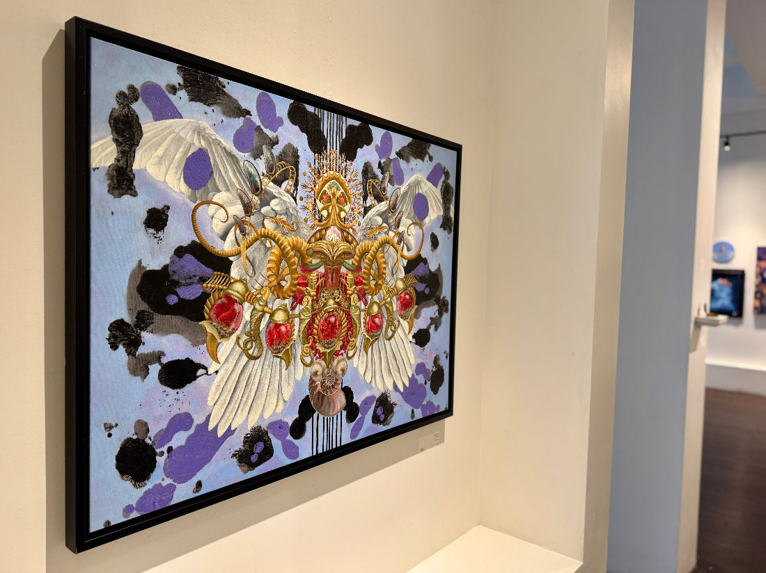 Framed artwork with butterfly design on a wall in an art gallery.