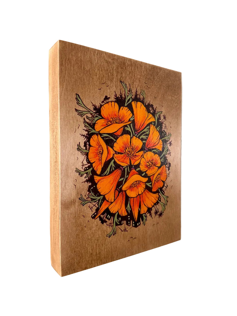 Wooden wall art with orange floral design on a plain background