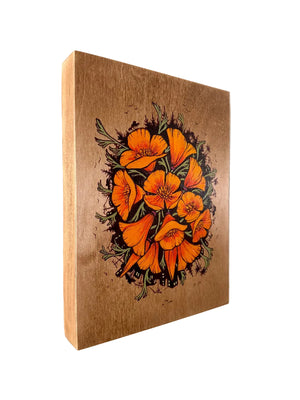Wooden wall art with orange floral design on a plain background