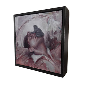 Framed artwork of a person with a bird on their head, mounted on a wall.